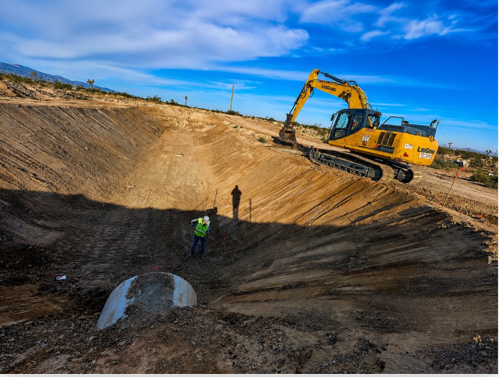 Excavator shaping a commercial retention basin
